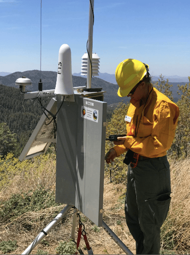 Julie Malingowski taking meteorological measurements in the field. (Photo courtesy of Julie Malingowski)